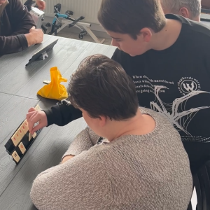 Chłopiec instruuje uczestniczkę ŚDS podczas gry w Rummikub