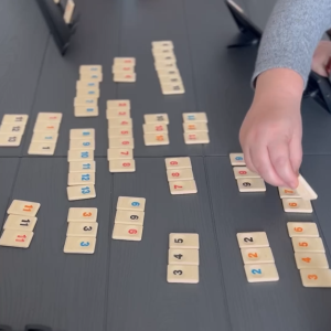 Na macie leżą poukładany kostki do gry w Rummikub