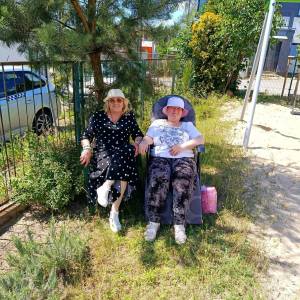 Dwie  uczestniczki ŚDS siedzą na leżakach w ogrodzie ŚDS