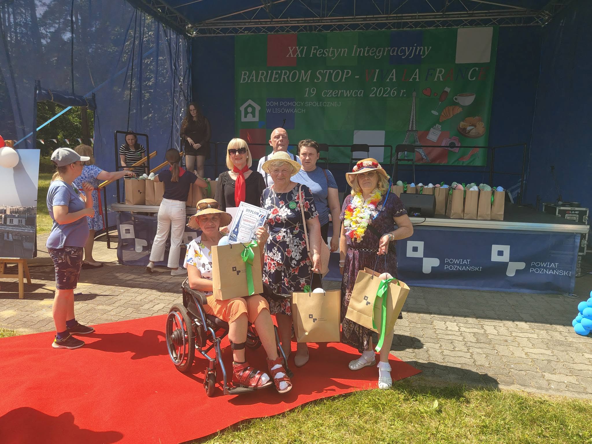 Uczestnicy ŚDS pozują do zdjęcia na czerwonym dywanie pod sceną festynu