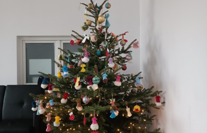 Choinka ozdobiona kolorowymi bombkami, zawieszkami i światełkami
