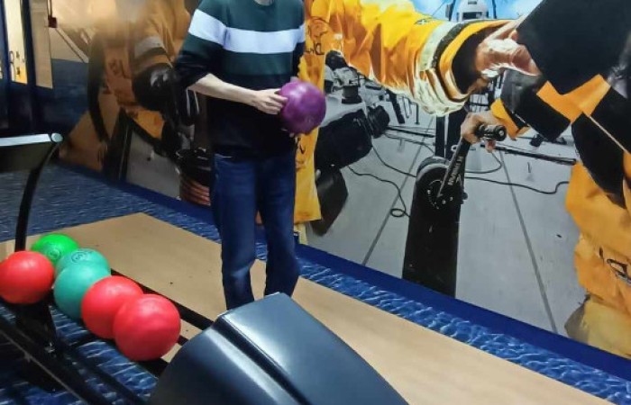 Chłopak stoi przy podajniku do kul i przygotowuje się do rzutu 