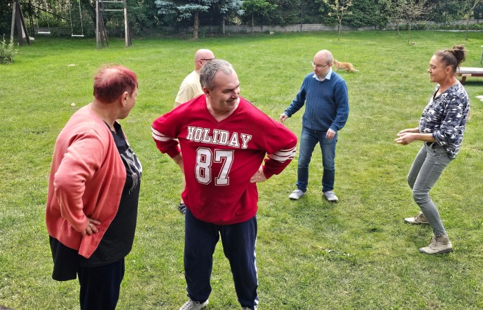 Osoby tańczą i rozmawiają na ogródku 