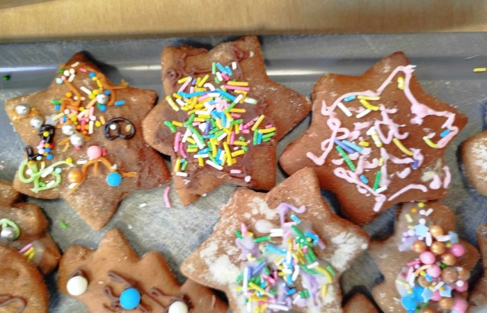 Pierniczki w kształcie gwiazdek, ozdobionych kolorowymi posypkami i lukrem