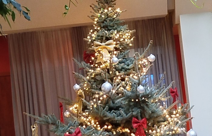 Dwie uśmiechnięte osoby pozujące do zdjęcia w ozdobnej ramce z napisem Sylwester, w kolorowych akcesoriach imprezowych