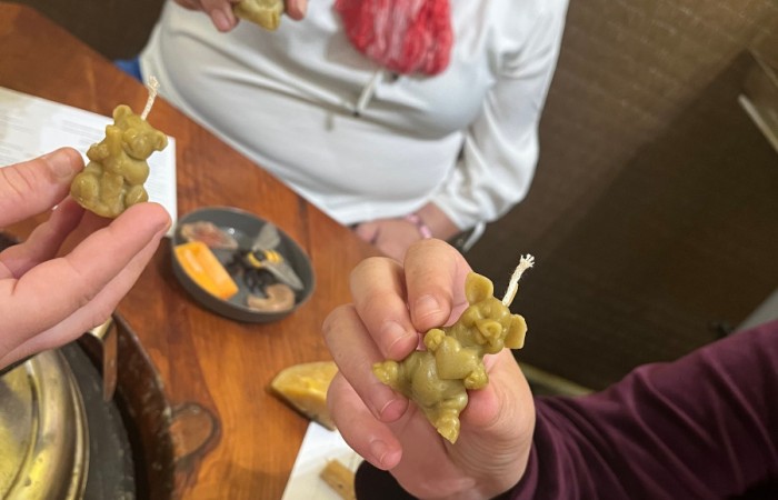 Uczestnicy ŚDS pokazują swoje świeczki z wosku. Widać świeczkę w kształcie sowy, prosiaczka i misia a także małpy