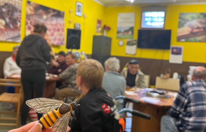 Uczestnicy ŚDS w warsztatowni muzeum. Osoba najbliżej kamery trzyma w dłoni malutki model królowej pszczół