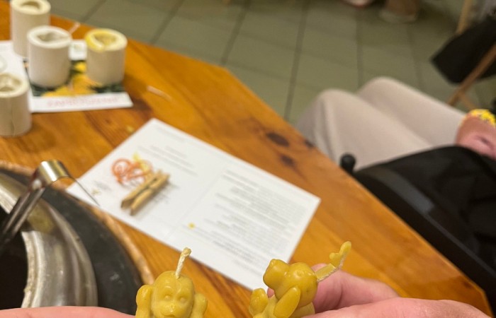 Uczestnicy ŚDS pokazują swoje świeczki z wosku. Widać świeczkę w kształcie małpki i pieska